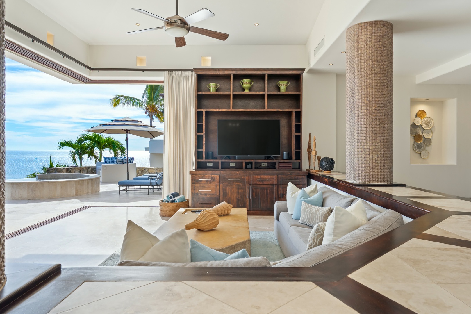 Sink into plush sofas while ocean breezes flow through your open living space, where modern comfort meets stunning sea views.