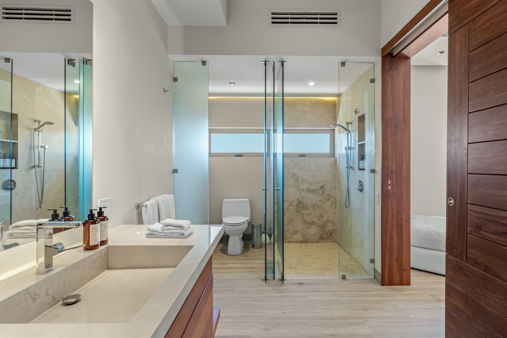 Step into your luxurious ensuite with its spa-like dual shower, elegant marble counters, and warm wood accents—your private sanctuary awaits.