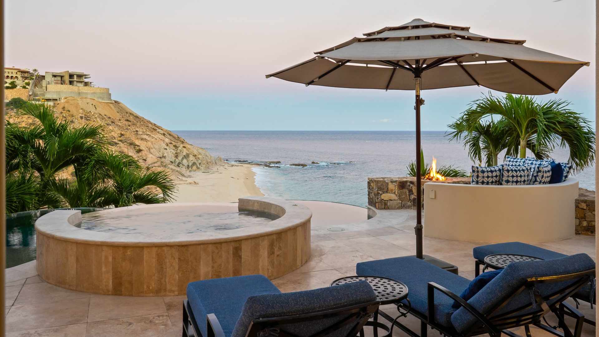 Unwind in your private hot tub while waves whisper nearby, with plush loungers and shade creating your perfect beachfront sanctuary.
