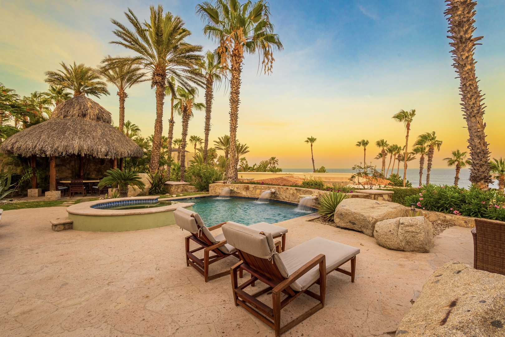 A stunning tropical retreat awaits in this oceanfront setting, where swaying palms frame your private pool and hot tub. Sink into lounge chairs as the sun paints the sky and water in golden hues.