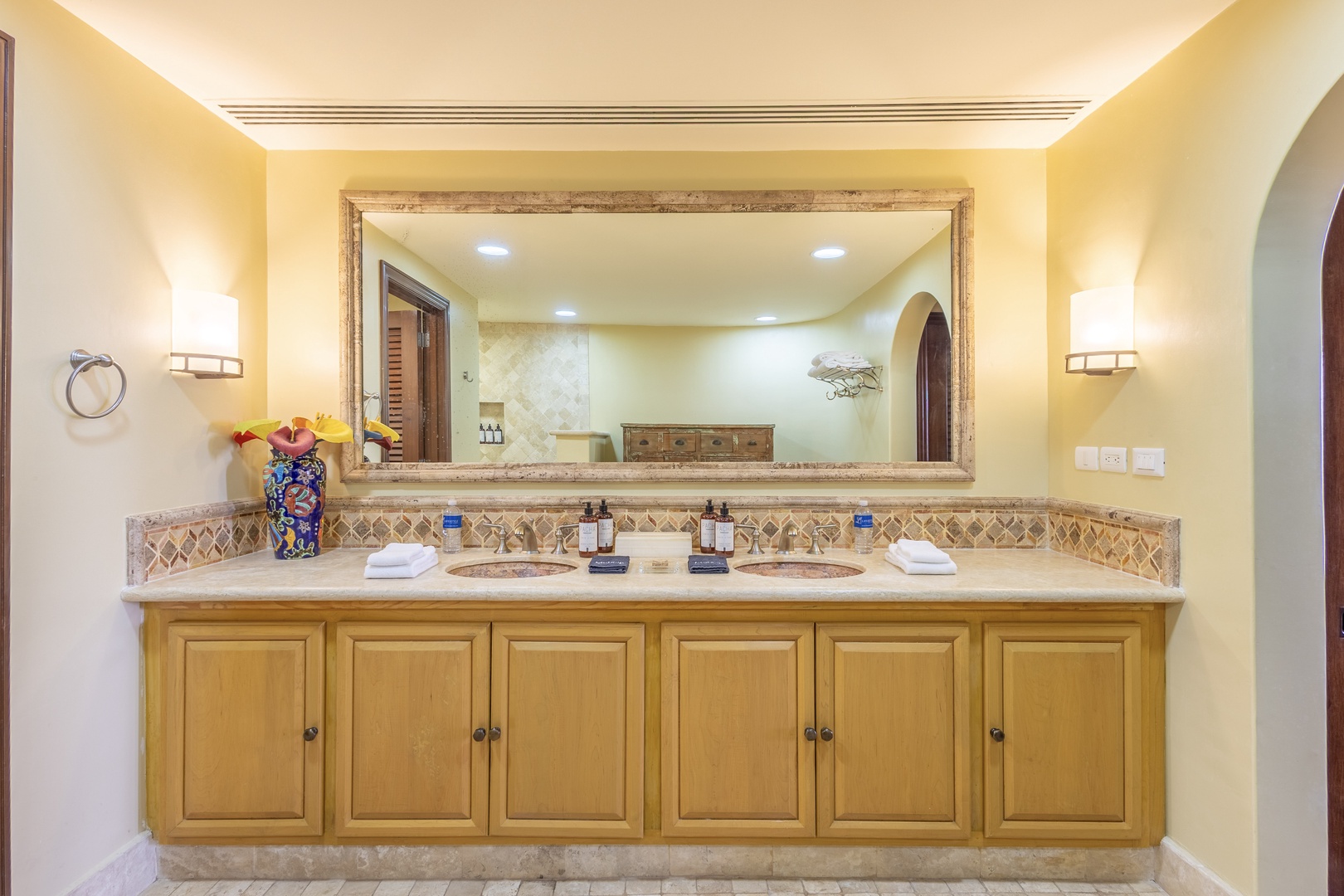 Your private spa-like bathroom features dual sinks, elegant tile work, soft lighting, and thoughtful touches like fresh towels and premium toiletries ready for your arrival.