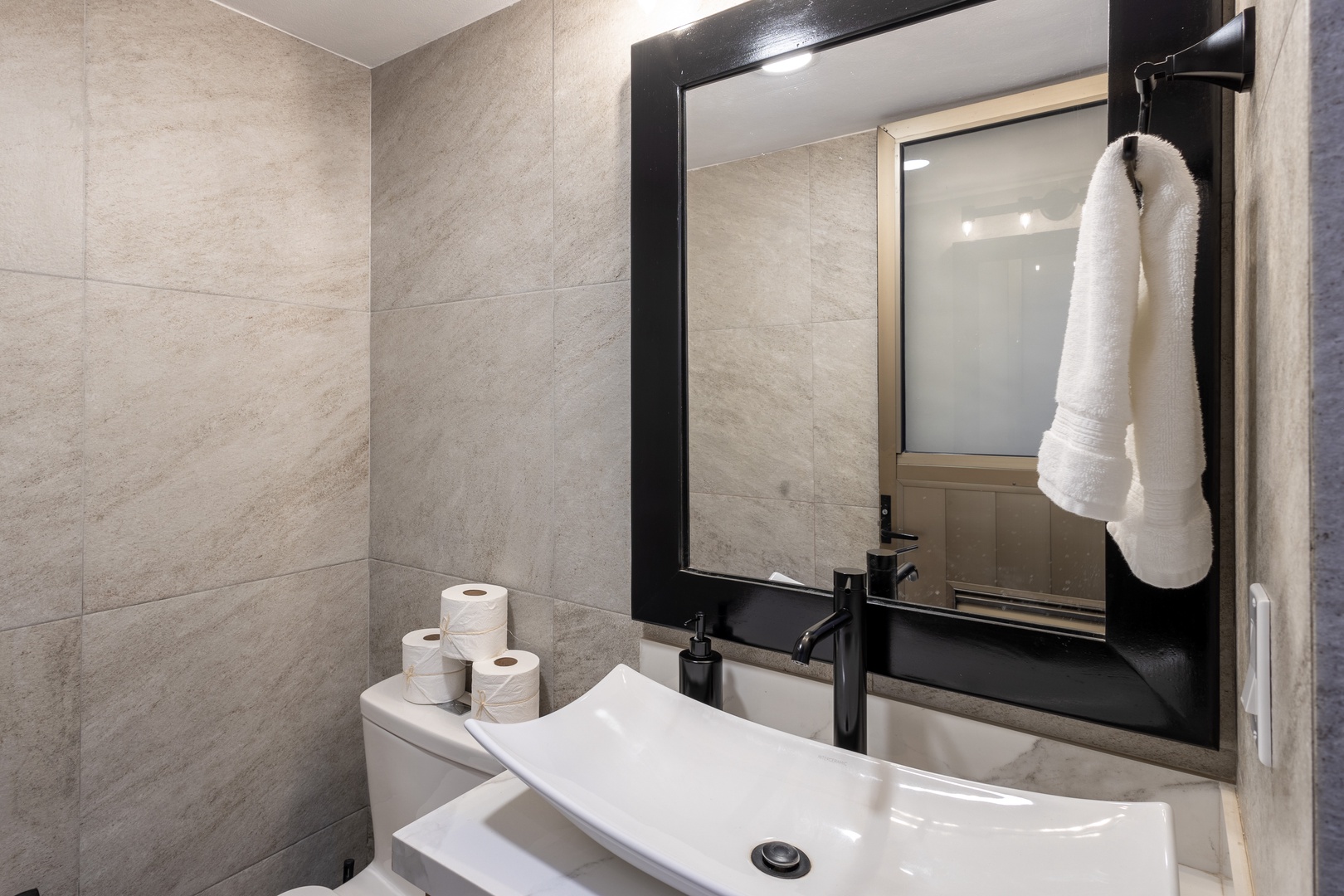 Refresh in your modern bathroom with sleek tile, a contemporary vanity, and plush towels ready for you after a relaxing shower.