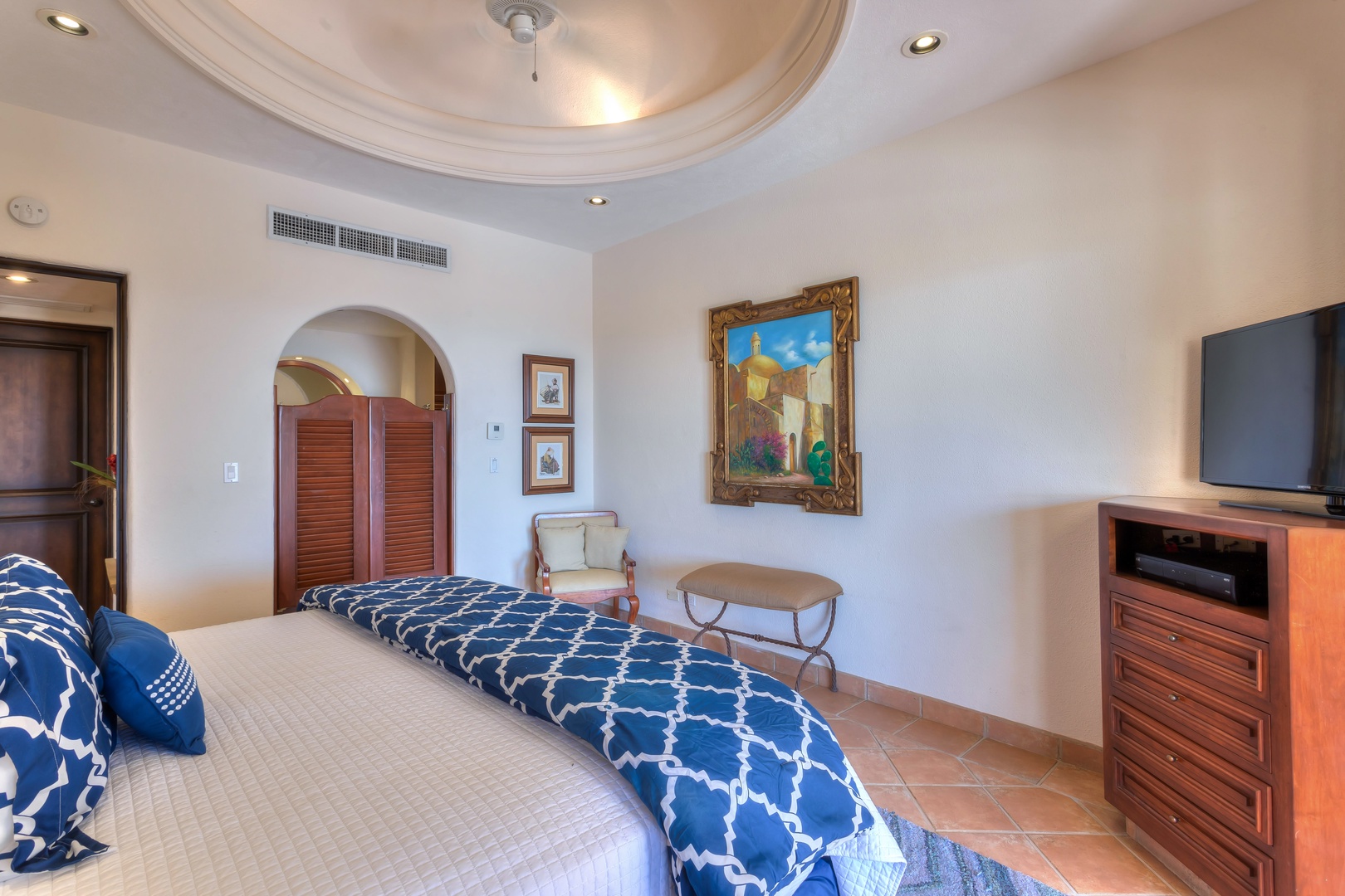 Your elegant master suite features a coffered ceiling, rich wood furnishings, and Mediterranean charm that creates a peaceful retreat.