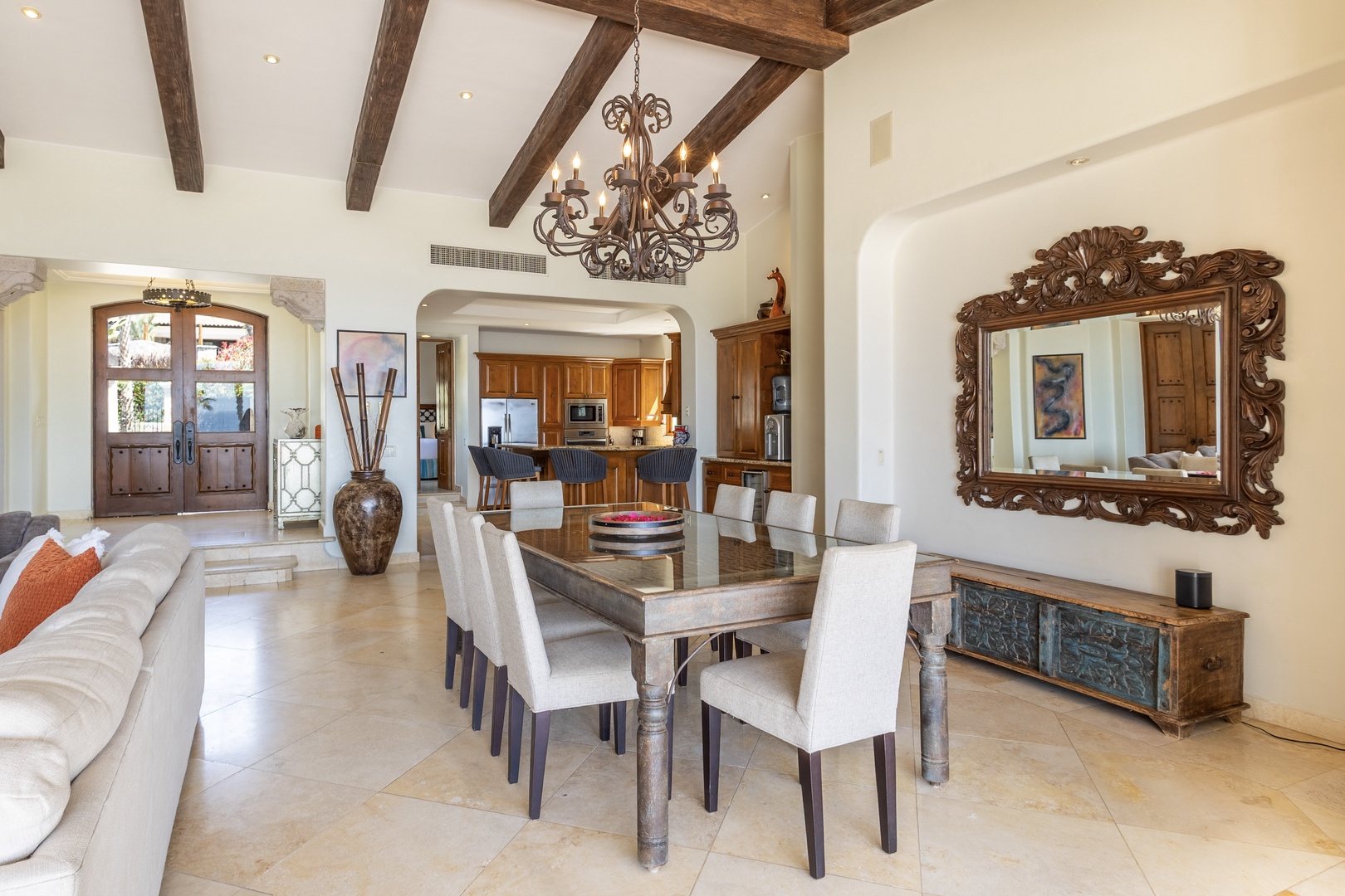 Gather around this stunning dining table beneath rustic beams and an elegant chandelier for memorable meals together.