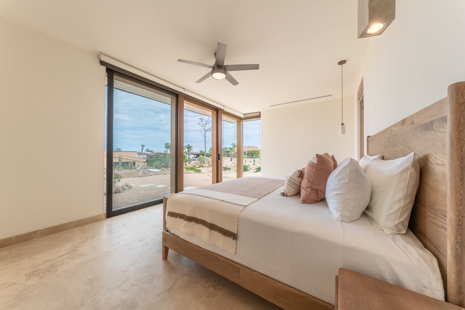 Your serene bedroom offers a plush bed, soothing neutral tones, and expansive windows framing desert views—perfect for peaceful mornings and restful nights.