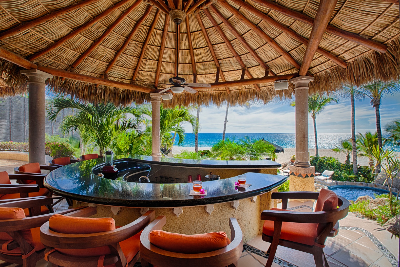 Sip tropical drinks at your beachfront tiki bar while ocean waves dance beyond swaying palms.