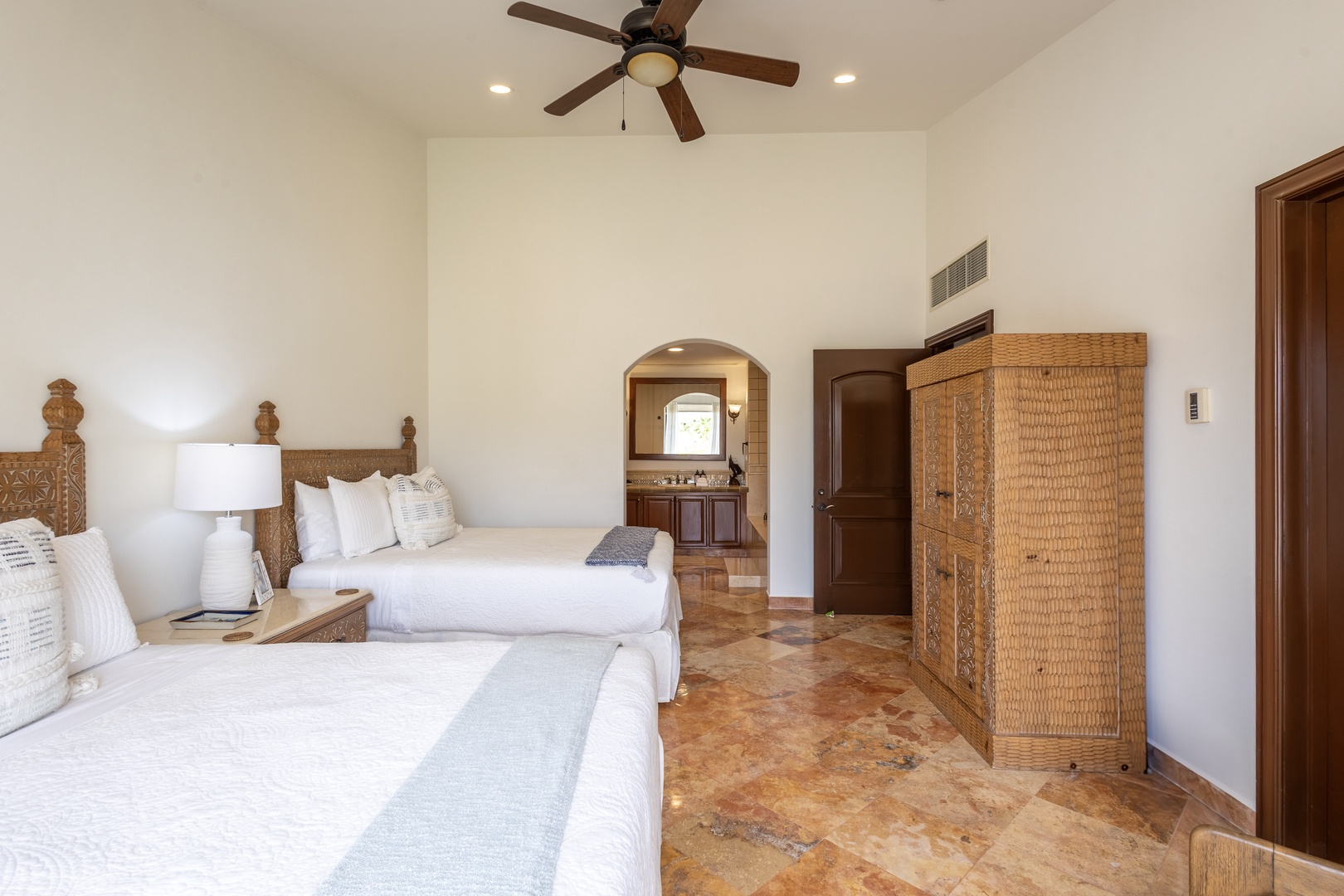 Drift into restful sleep in your elegant twin bedroom, where natural textures and gentle ceiling fan create perfect comfort for sharing.