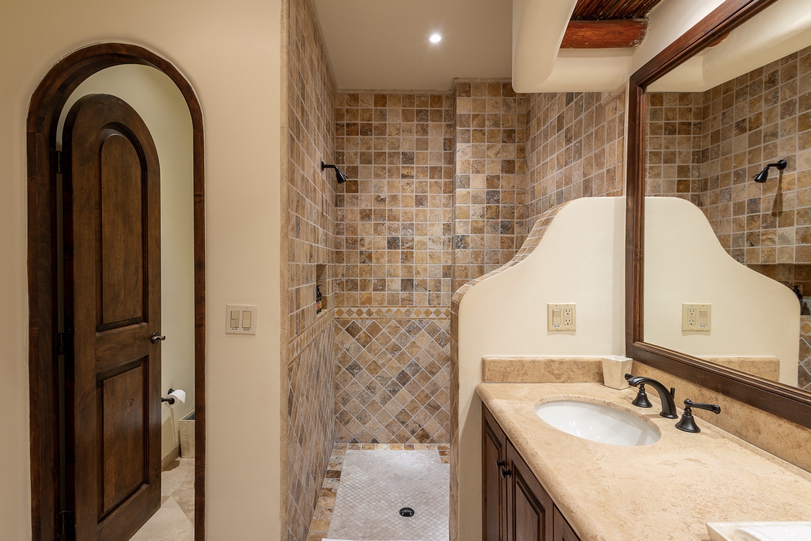 Your private bathroom combines rustic elegance with modern comfort—warm stone tile, a sleek vanity, and a refreshing walk-in shower welcome you after each day's adventure.