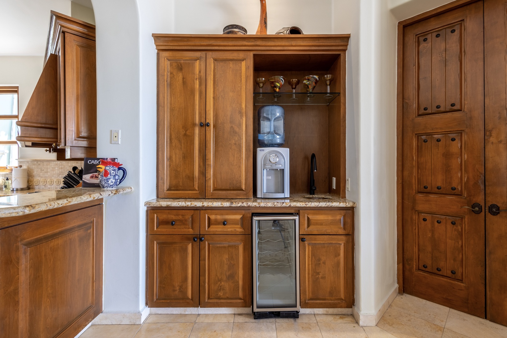 Your in-home beverage station awaits—complete with a water cooler, wine fridge, and handcrafted cabinetry. Grab a cool drink or uncork your favorite bottle whenever the mood strikes.