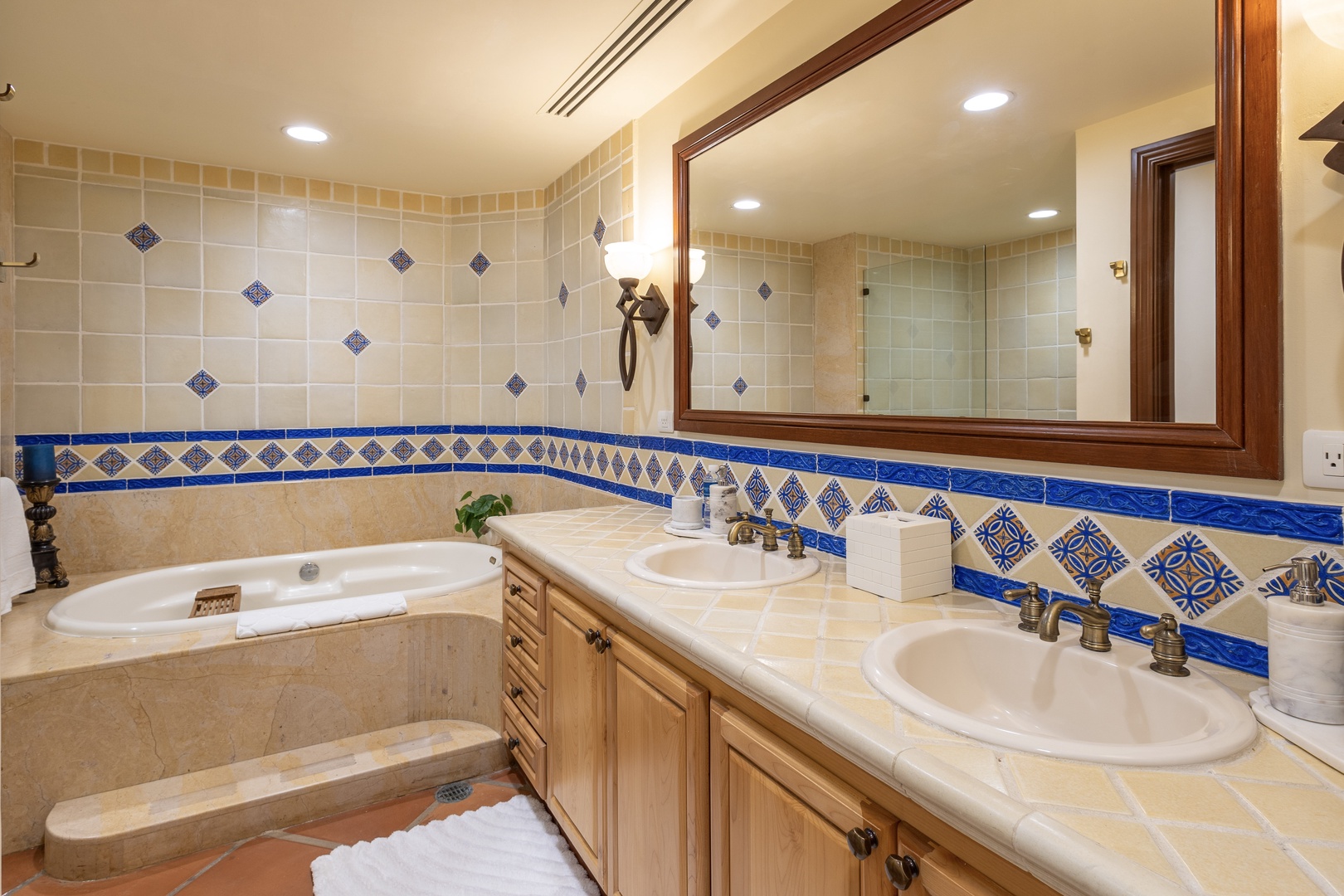 Unwind in your luxurious bathroom featuring hand-painted Mexican tiles, a spacious soaking tub, and dual vanities—your perfect retreat after exploring.