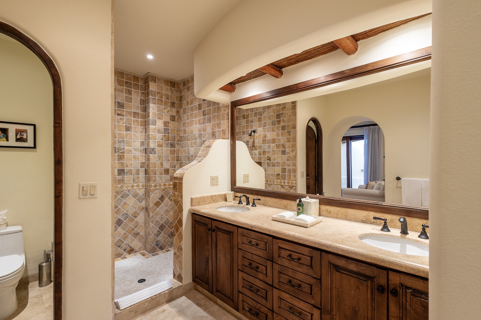 Step into your private spa-like sanctuary, where warm wood tones and natural stone create a peaceful retreat. The spacious walk-in shower and double vanity offer comfort and convenience for your stay.