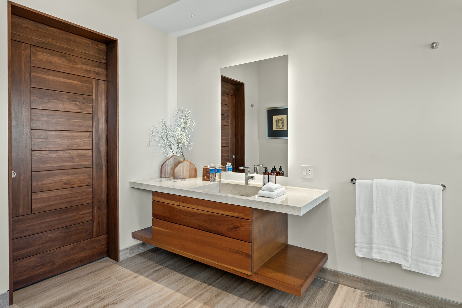 Step into your private bathroom retreat with warm wood accents, a sleek marble vanity, and plush towels waiting just for you.