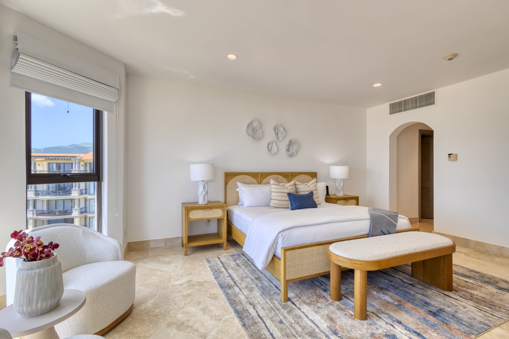 Your serene bedroom retreat awaits with soft linens, warm natural wood accents, and gentle light streaming through the window. Sink into comfort after a day of adventure.