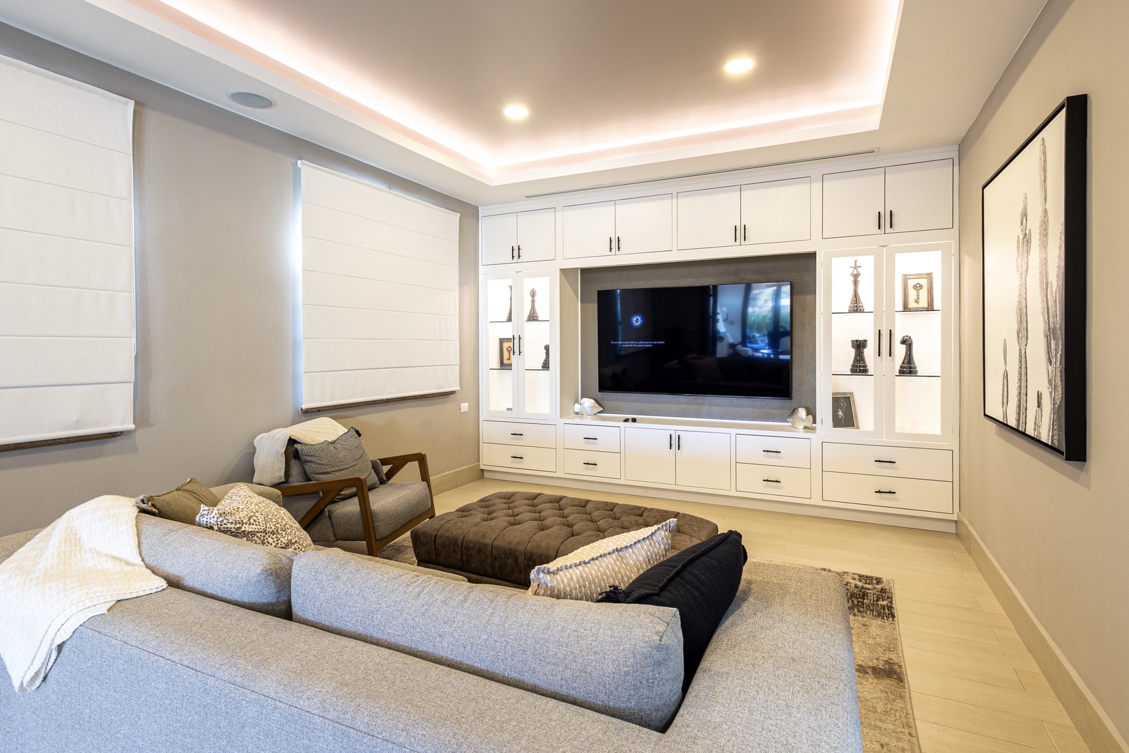 Sink into your cozy sectional for movie nights in this elegant media room. Built-in storage keeps everything tidy while you unwind under soft cove lighting and enjoy your home theater setup.