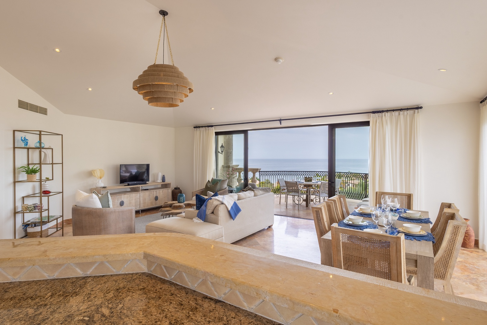 Unwind in your elegantly appointed living space where natural light floods through expansive windows, revealing stunning ocean views from your private balcony.