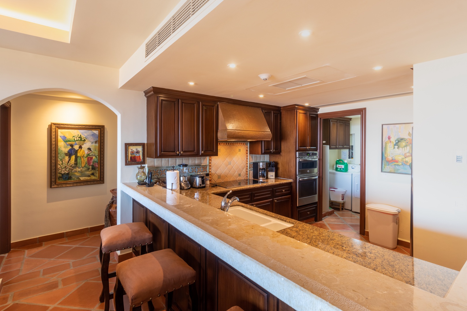 Your private kitchen awaits with rich wood cabinetry, granite countertops, and modern appliances. Enjoy preparing meals at the expansive breakfast bar or gathering with loved ones in this warm, inviting space.