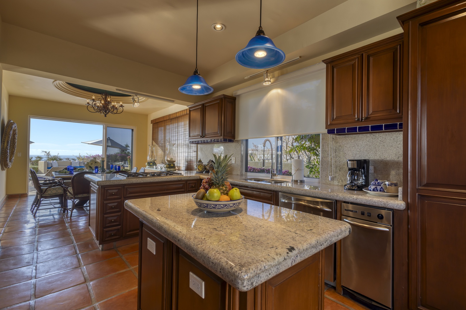 Cook memorable meals in your spacious gourmet kitchen, featuring granite countertops, stainless steel appliances, and warm blue pendant lighting.