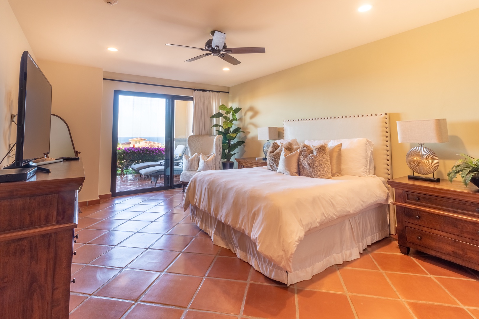 Sink into plush bedding and wake to stunning views through your private balcony doors. Warm terracotta tiles and elegant furnishings create a serene retreat for restful nights.