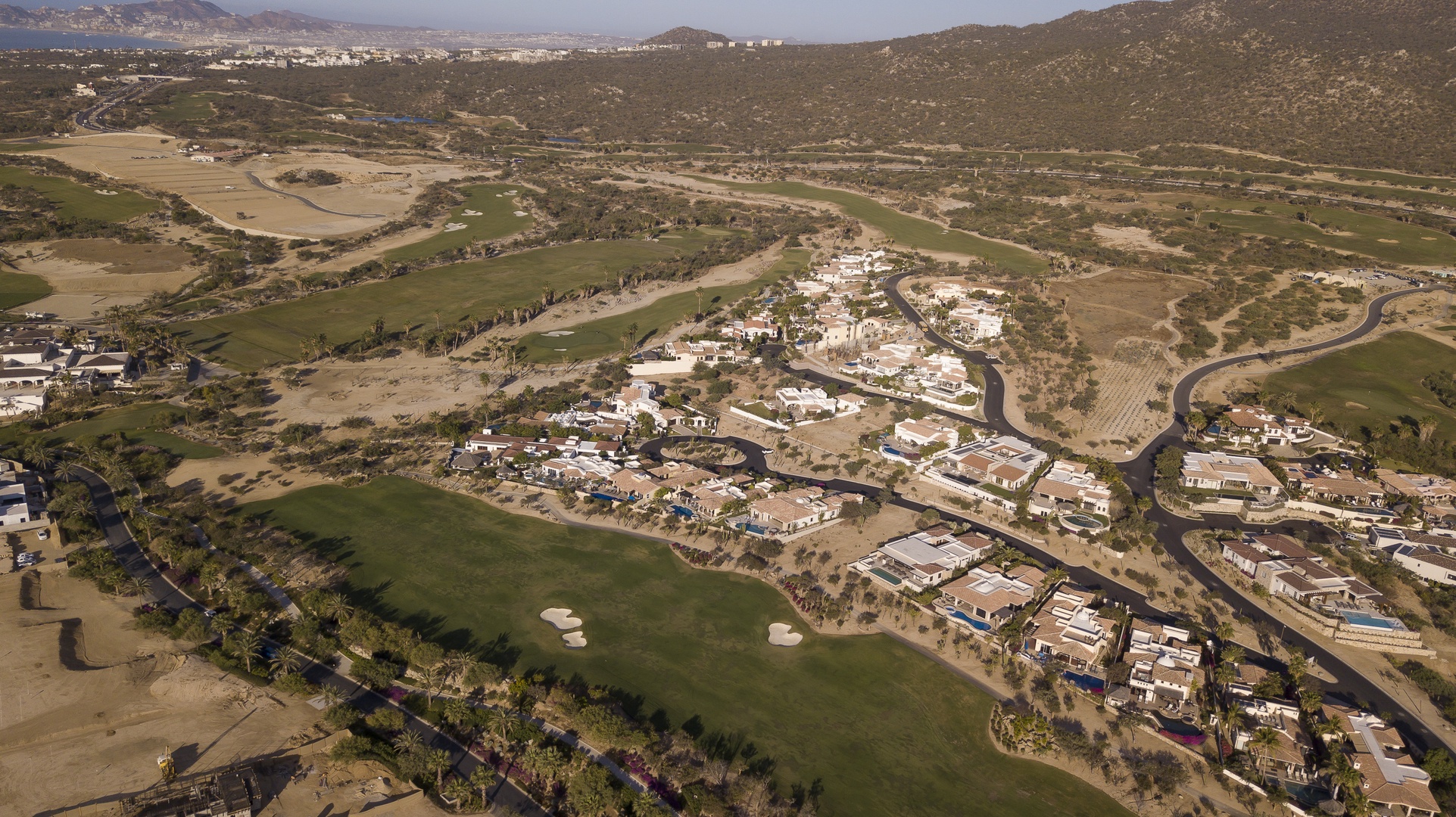 Aerial view showcases the stunning golf course community nestled among rolling hills and natural desert landscape.