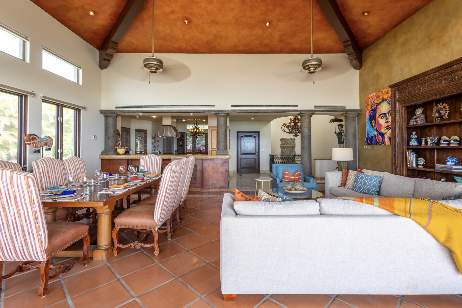 Sink into plush seating and gather around the dining table in this stunning open-concept space. Soaring vaulted ceilings, colorful artwork, and natural light create a warm, inviting atmosphere for your group.
