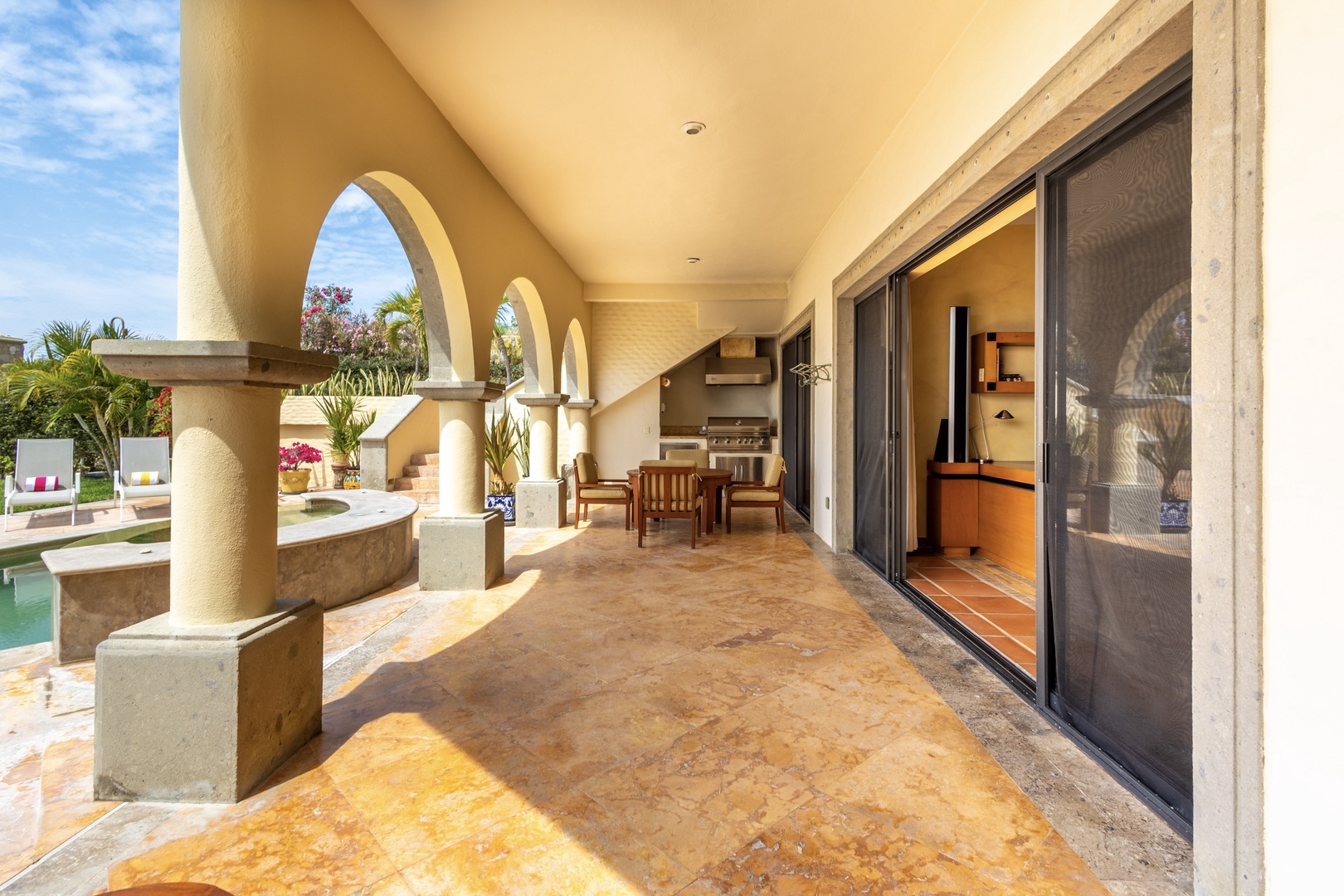 Step onto your covered terrace with elegant arched columns, where a dining set and BBQ await for memorable outdoor meals by the pool.
