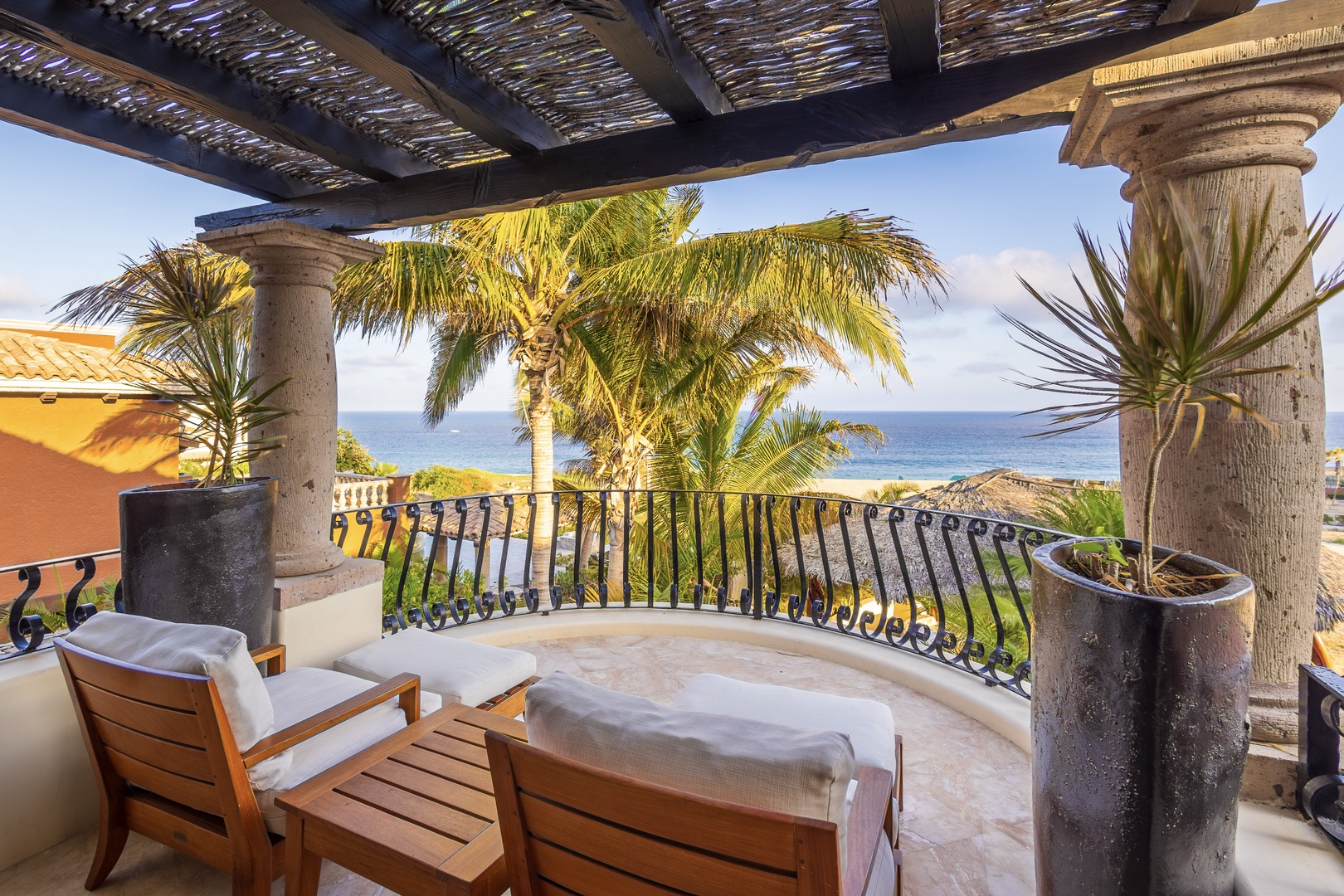 Unwind on your private terrace with sweeping ocean views, framed by swaying palms and a traditional palapa roof. Your perfect retreat awaits with comfortable seating and tropical ambiance.