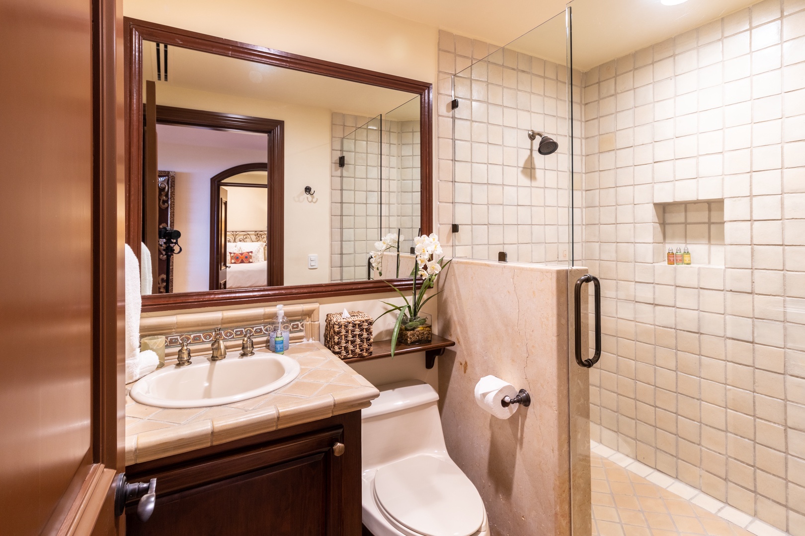Step into your private bathroom with elegant tilework, a walk-in shower, and thoughtful amenities. Fresh towels and toiletries await your arrival.