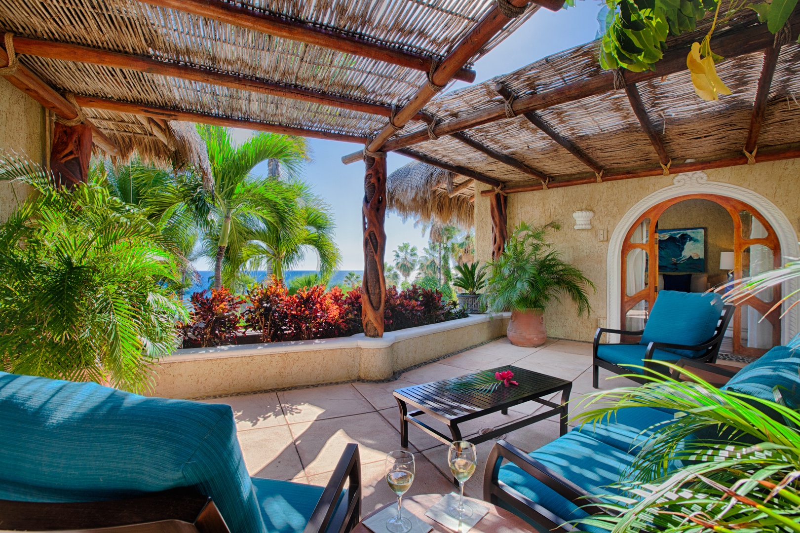 Unwind on your private terrace with turquoise loungers and tropical gardens framing stunning ocean views through bamboo shade.
