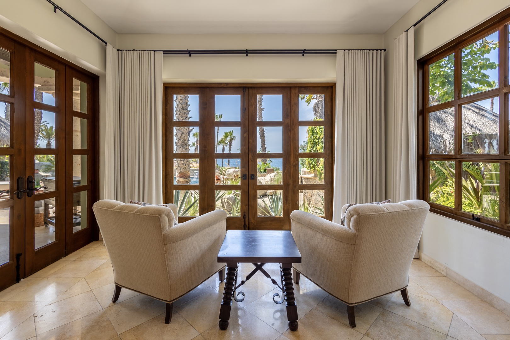 Sink into plush armchairs where natural light pours through French doors, offering peaceful garden views for your morning coffee.