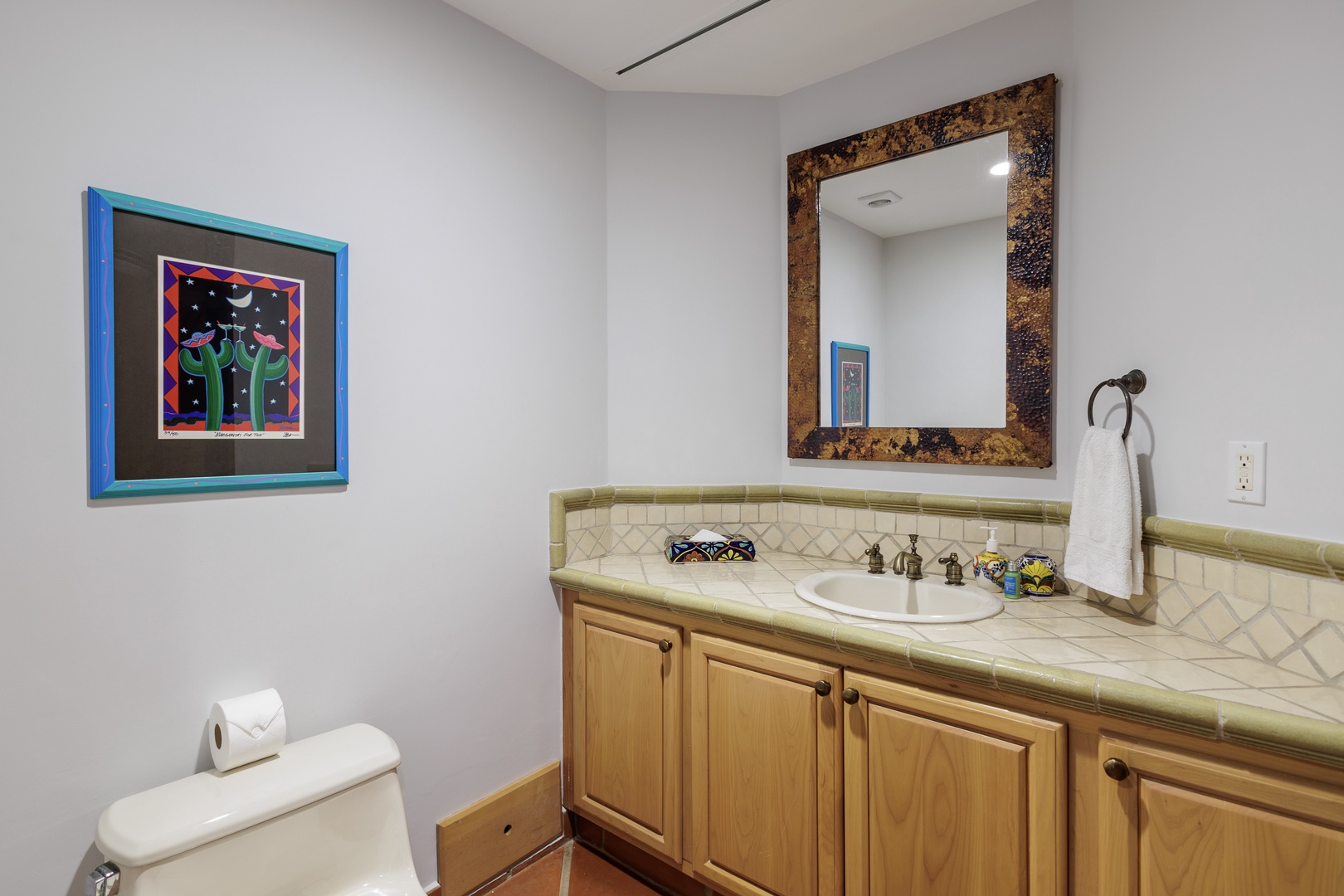 Step into your private bath with artful touches: a hand-painted sink, decorative tile, and warm wood vanity await your morning routine.
