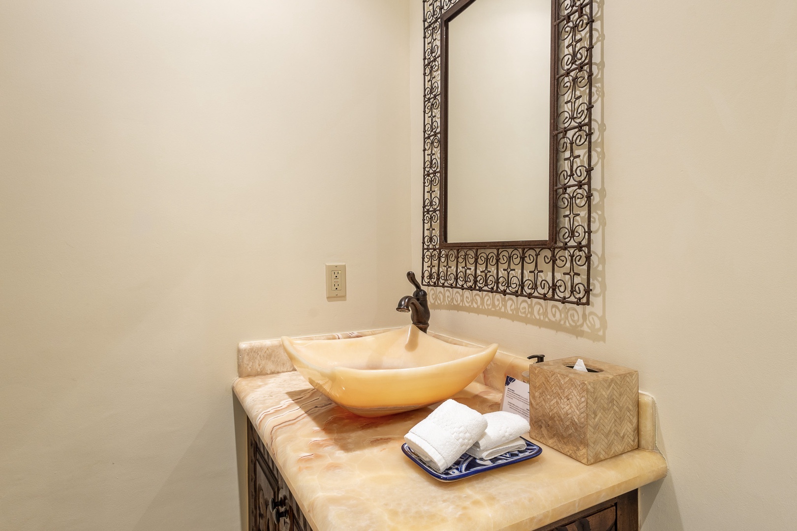 Freshen up at your elegant vanity, where warm stone meets artisan craftsmanship. Fluffy towels and thoughtful amenities await your arrival.