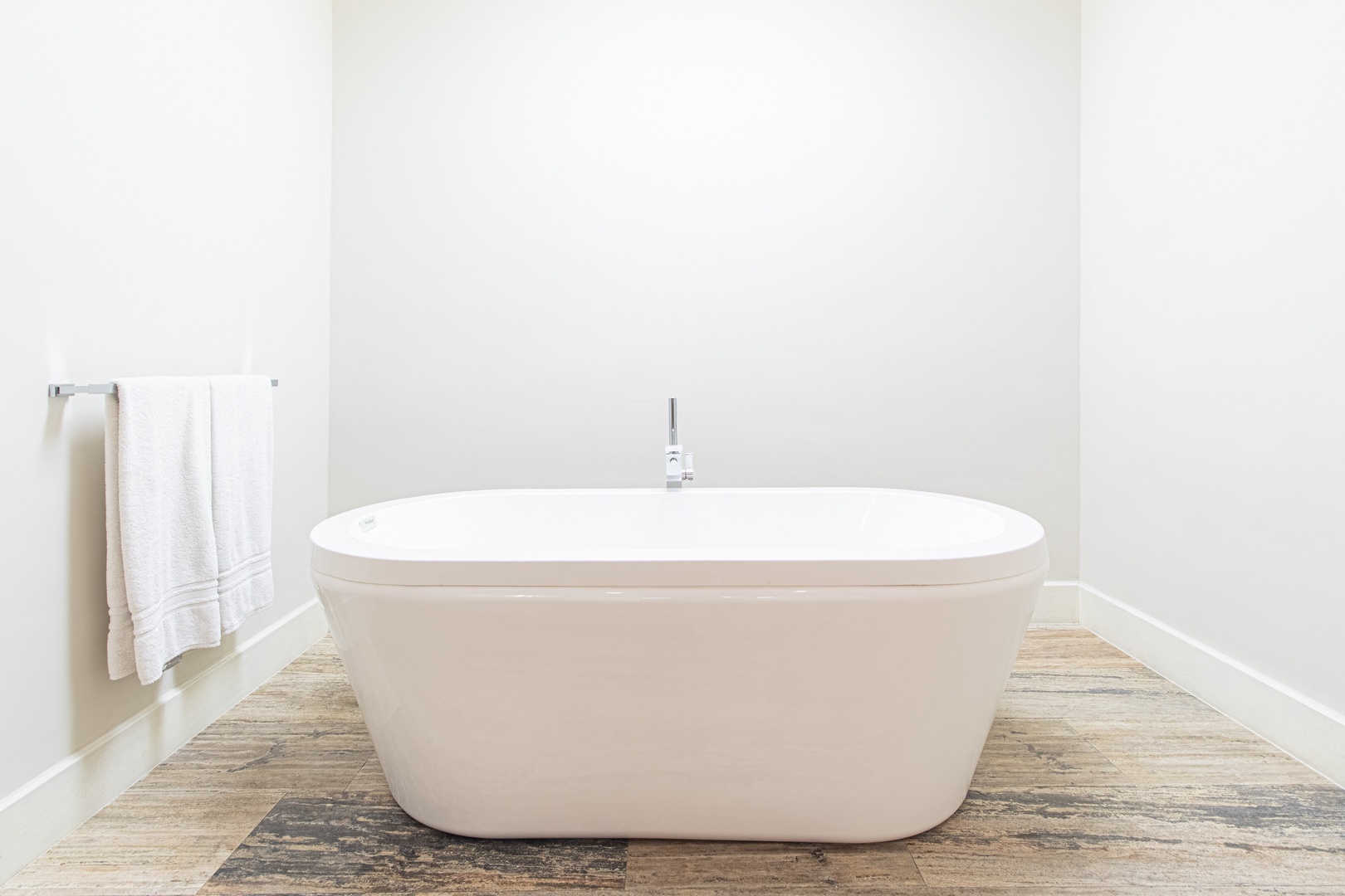Sink into this sleek freestanding tub and let the day's worries fade away. With plush towels within reach, your perfect soak awaits.