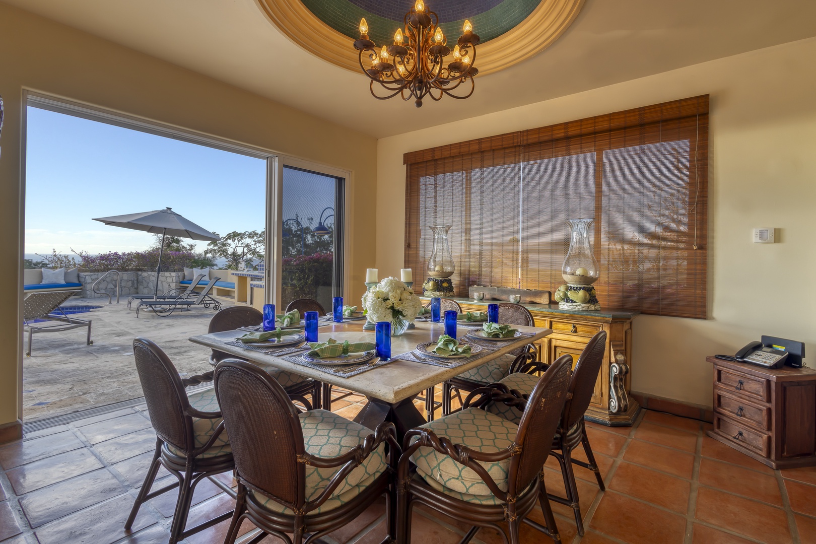 Gather around your elegant dining table with stunning patio views, where memorable meals unfold beneath warm chandelier light.