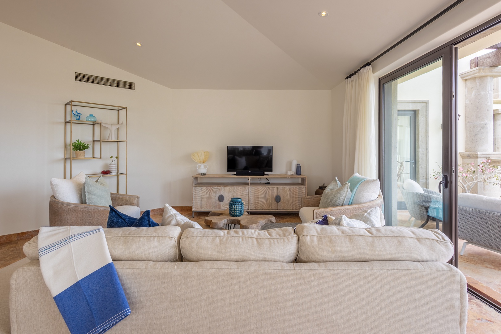 Relax in your spacious living room with plush seating, modern amenities, and glass doors opening to your private outdoor space.