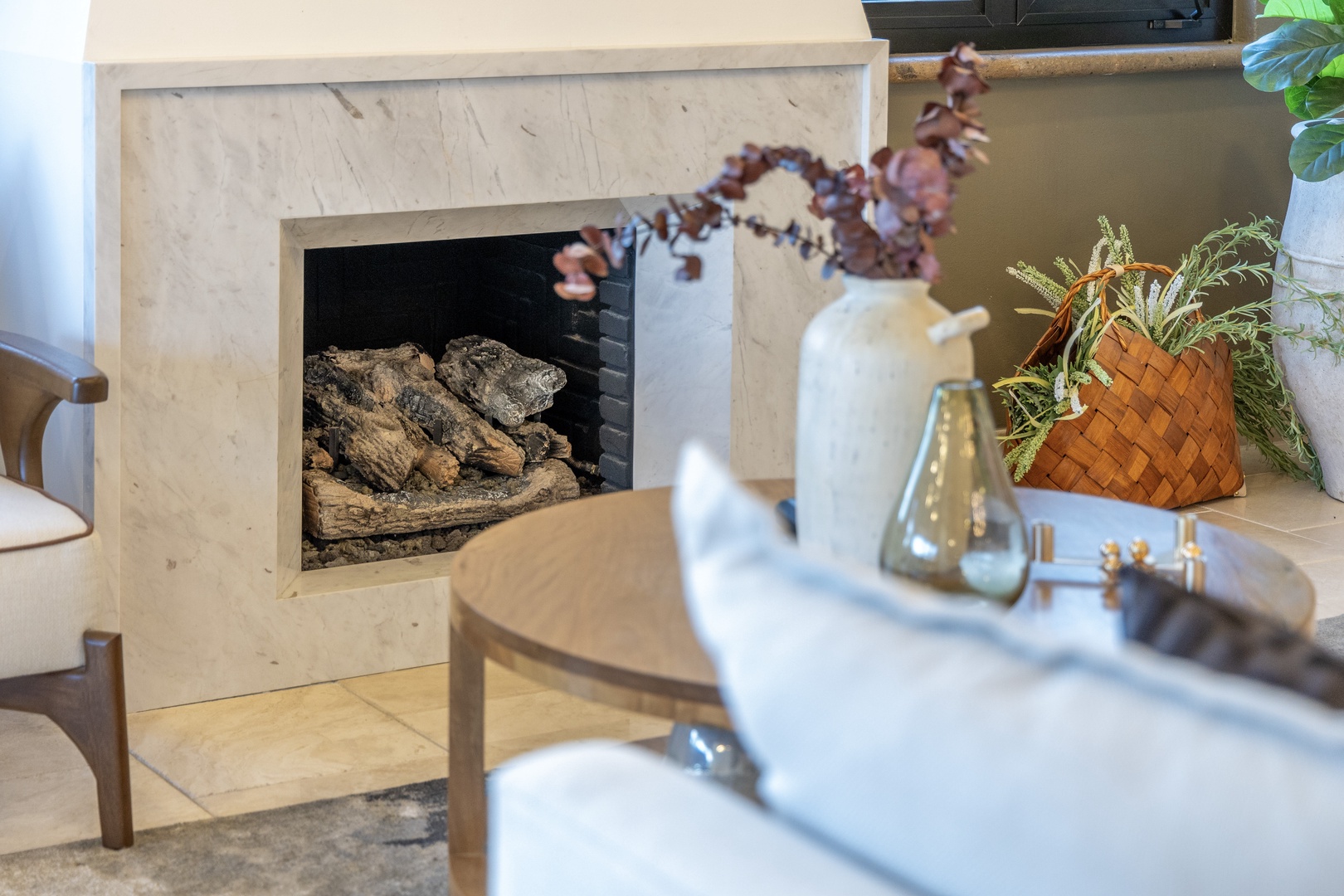 Curl up by the modern fireplace in your cozy living space, where natural light and warm décor create the perfect retreat for peaceful moments.