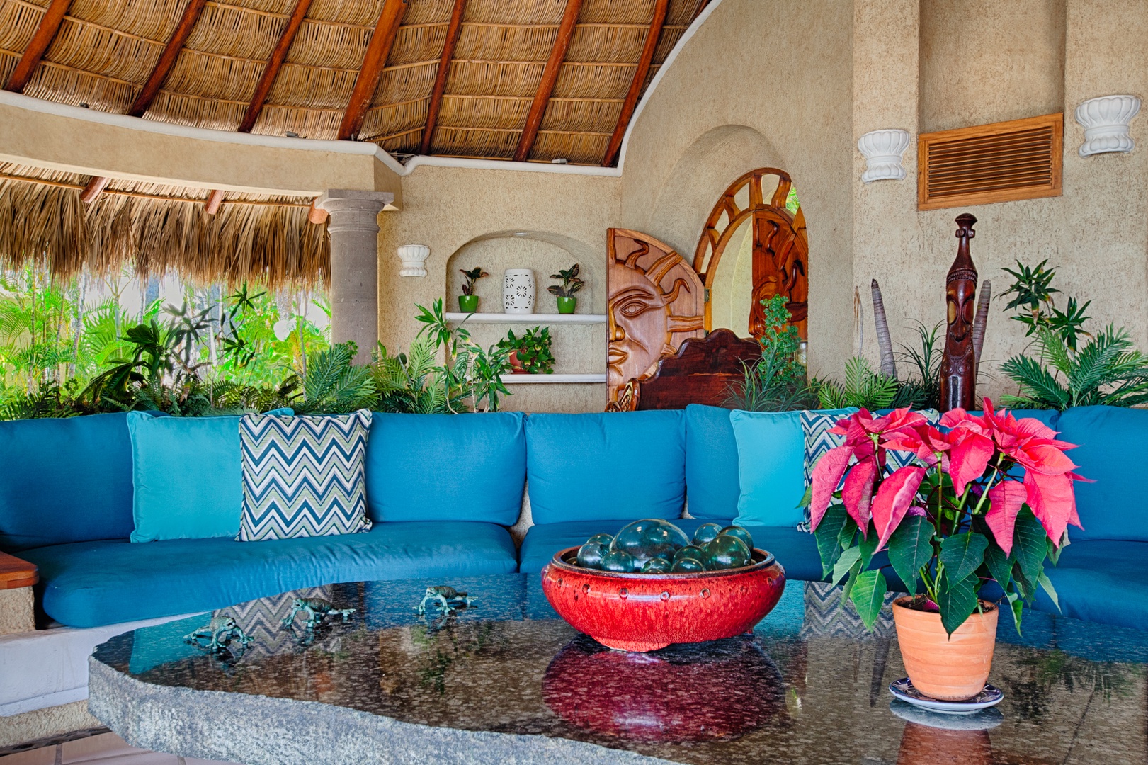 Unwind in your tropical paradise with authentic thatched ceilings, vibrant turquoise seating, and lush greenery creating the perfect island escape.