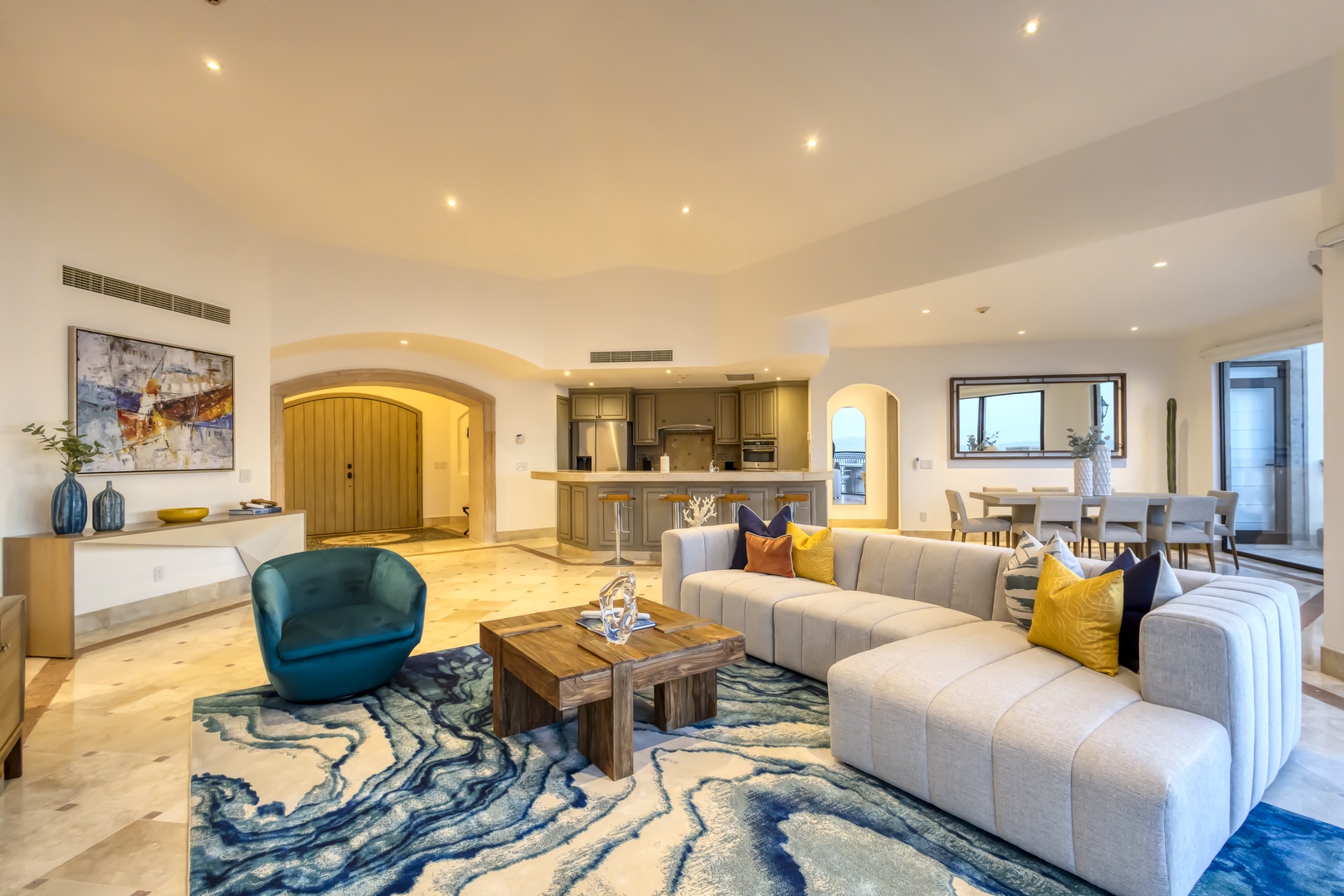 Sink into plush sofas beneath soaring ceilings with modern recessed lighting. Your open-concept living flows seamlessly into an elegant kitchen and bright dining nook, creating the perfect gathering space for your getaway.