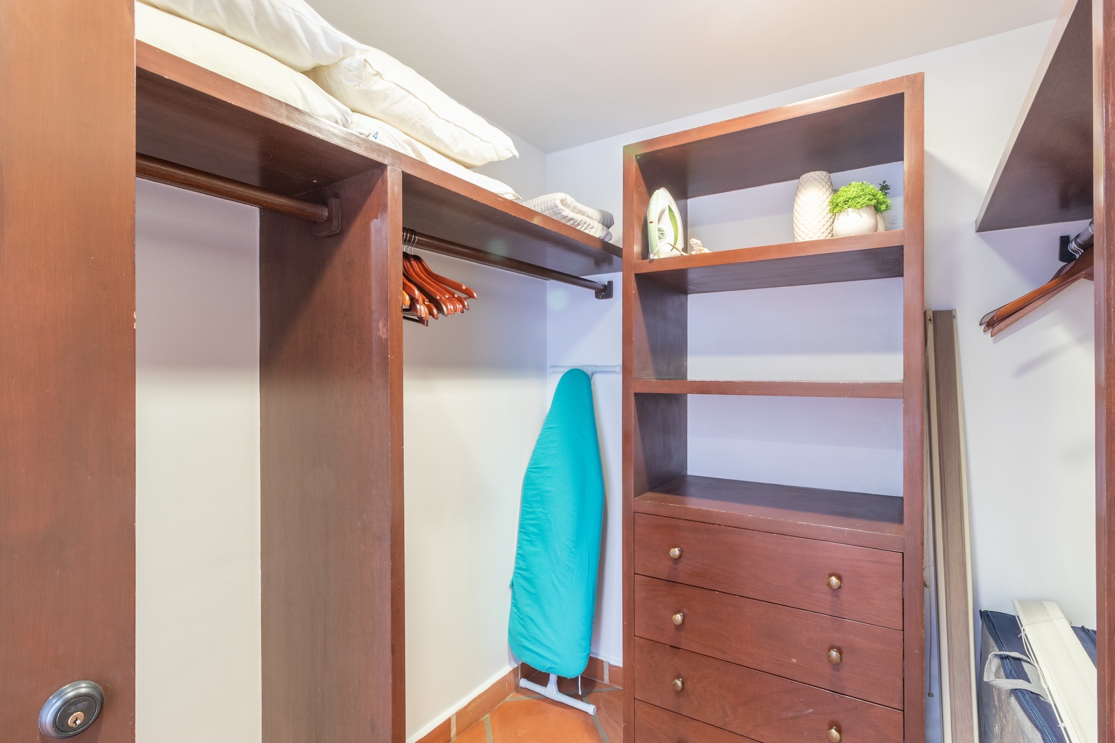 Your personal walk-in closet offers custom wooden shelving, hanging rods, and drawers to keep everything organized during your stay.