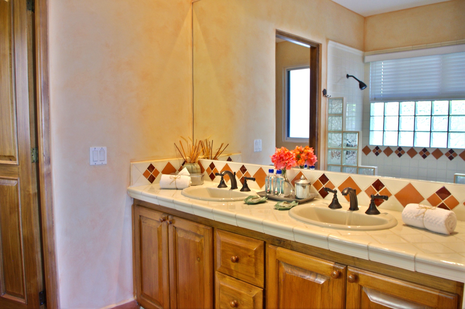 Refresh in your spacious bathroom featuring double sinks, warm southwestern-style tile accents, and natural light—perfect for getting ready for the day ahead.