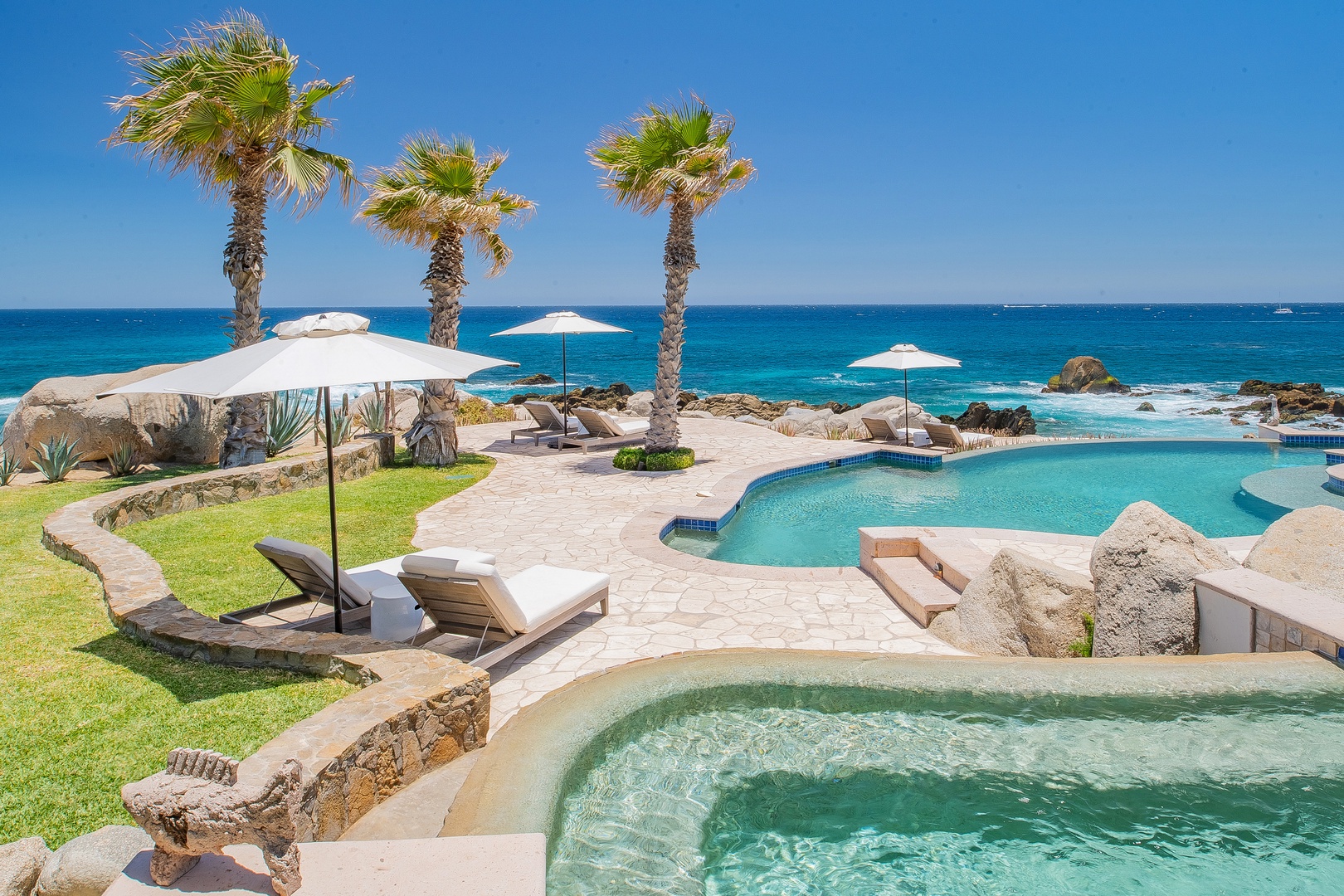 Soak in your private hot tub while gazing at turquoise waters and swaying palms in this oceanfront paradise.