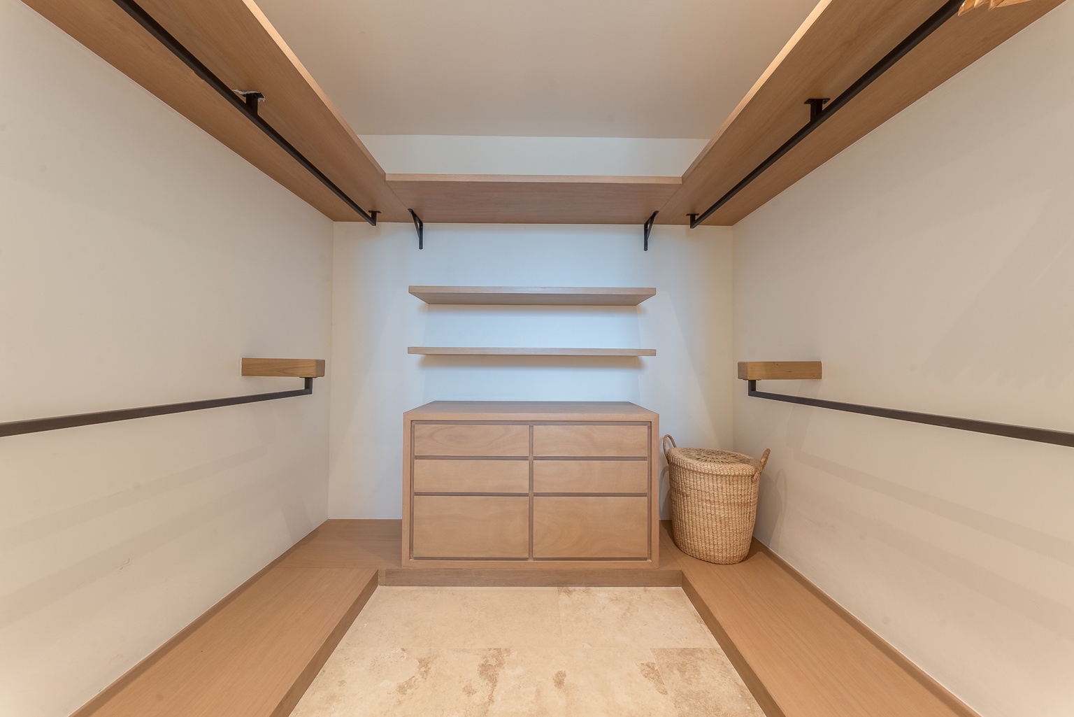 Generous walk-in closet with custom wood shelving and built-in drawers offers ample storage to keep your belongings organized during your stay.
