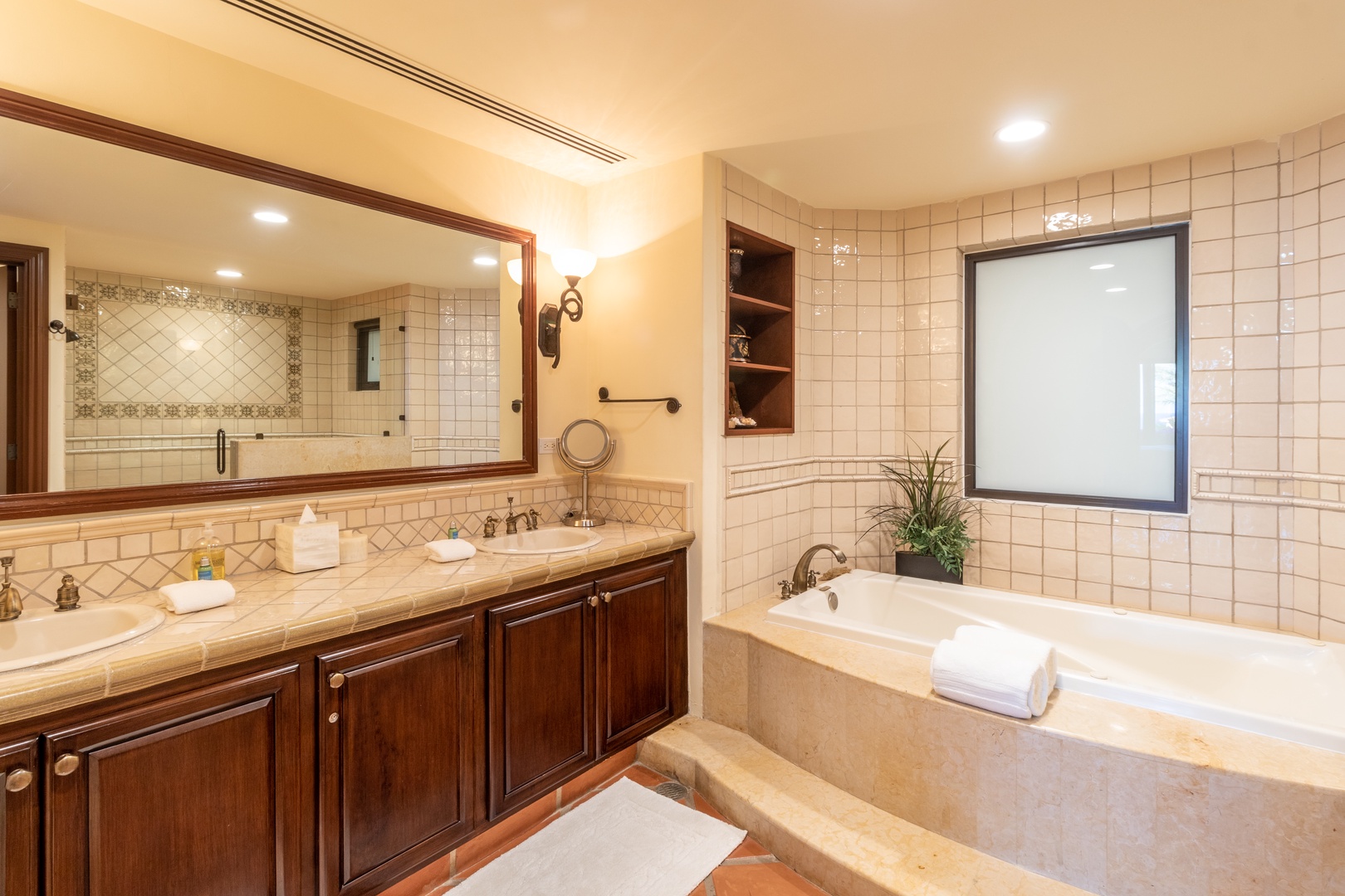 Your private retreat features elegant tile work, a spacious soaking tub, dual vanities, and warm wood accents—perfect for unwinding after a day of adventure.