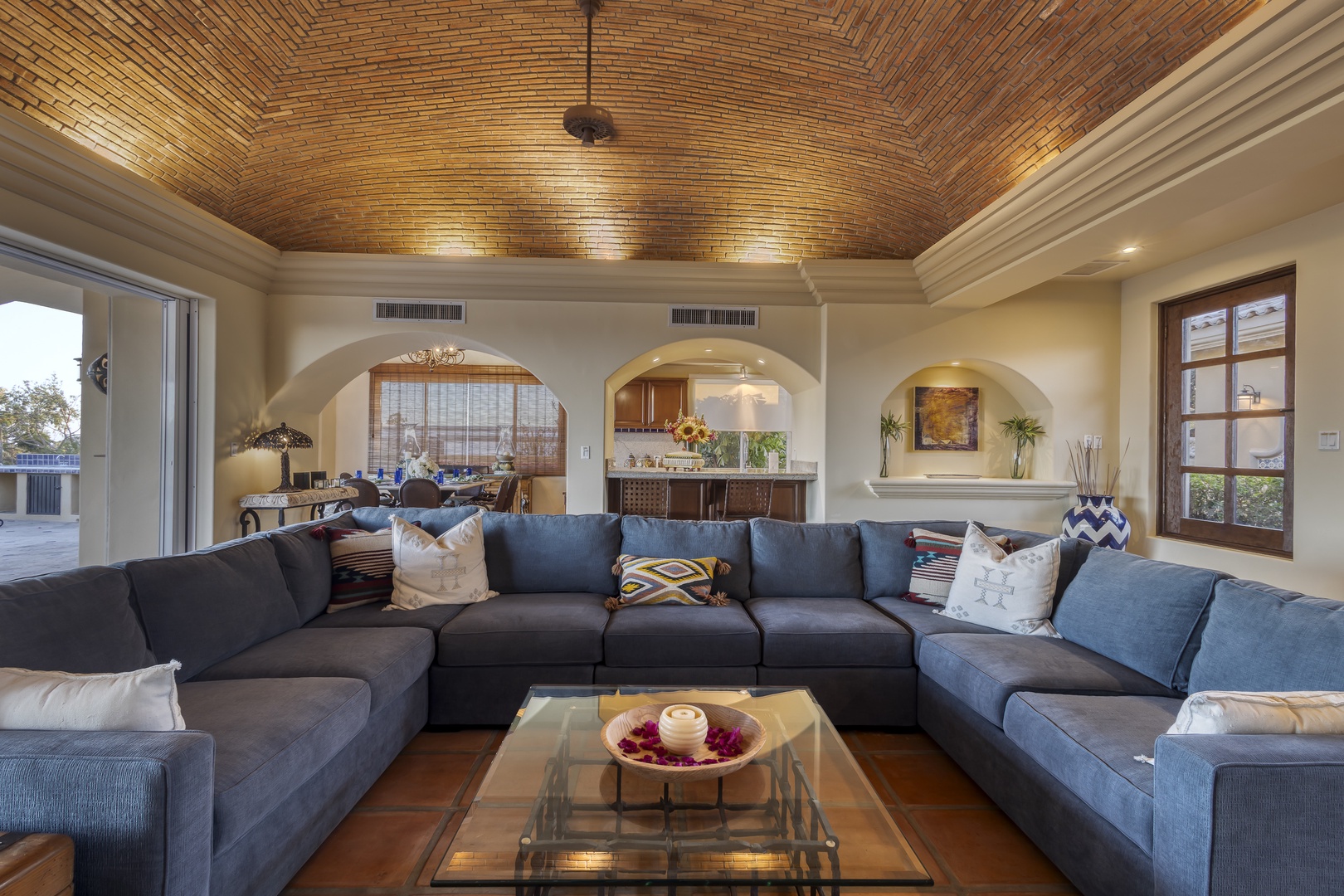 Unwind in your expansive living room featuring a stunning brick barrel ceiling and plush sectional seating for memorable gatherings.