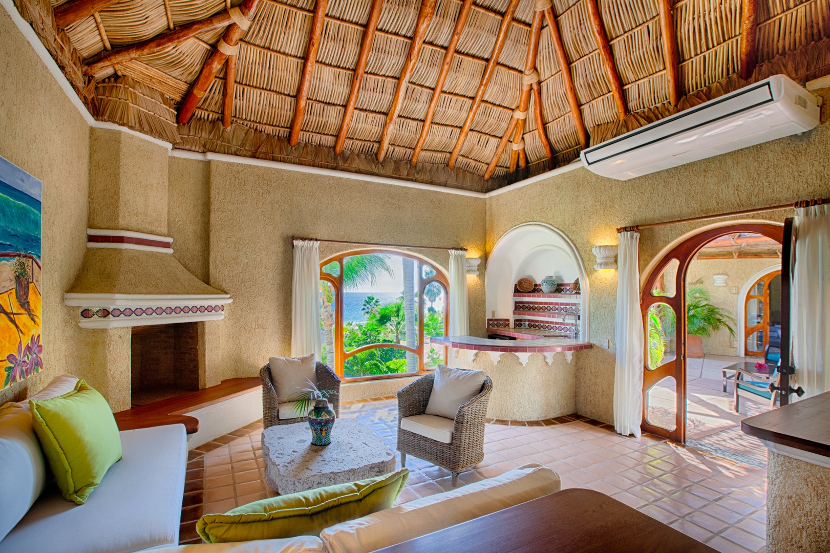 Relax under this stunning thatched palapa ceiling while tropical breezes flow through arched windows, creating your perfect island sanctuary.
