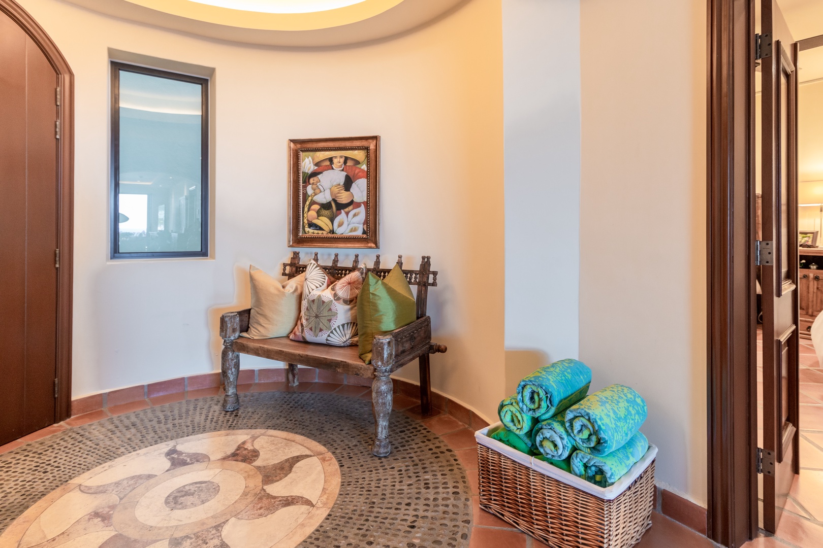 You'll love this warm, welcoming entryway with handcrafted decor, colorful art, and a thoughtful basket of pool towels ready for your sunny adventures.