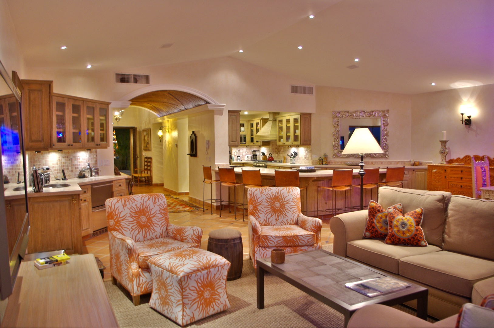 Relax in your spacious open-concept living area with a fully-equipped gourmet kitchen, elegant seating, and warm ambient lighting perfect for gathering with loved ones.