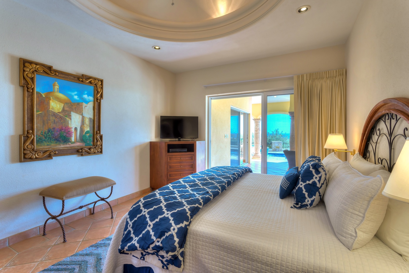 Unwind in your elegant suite featuring a plush bed and stunning pool views through floor-to-ceiling doors.