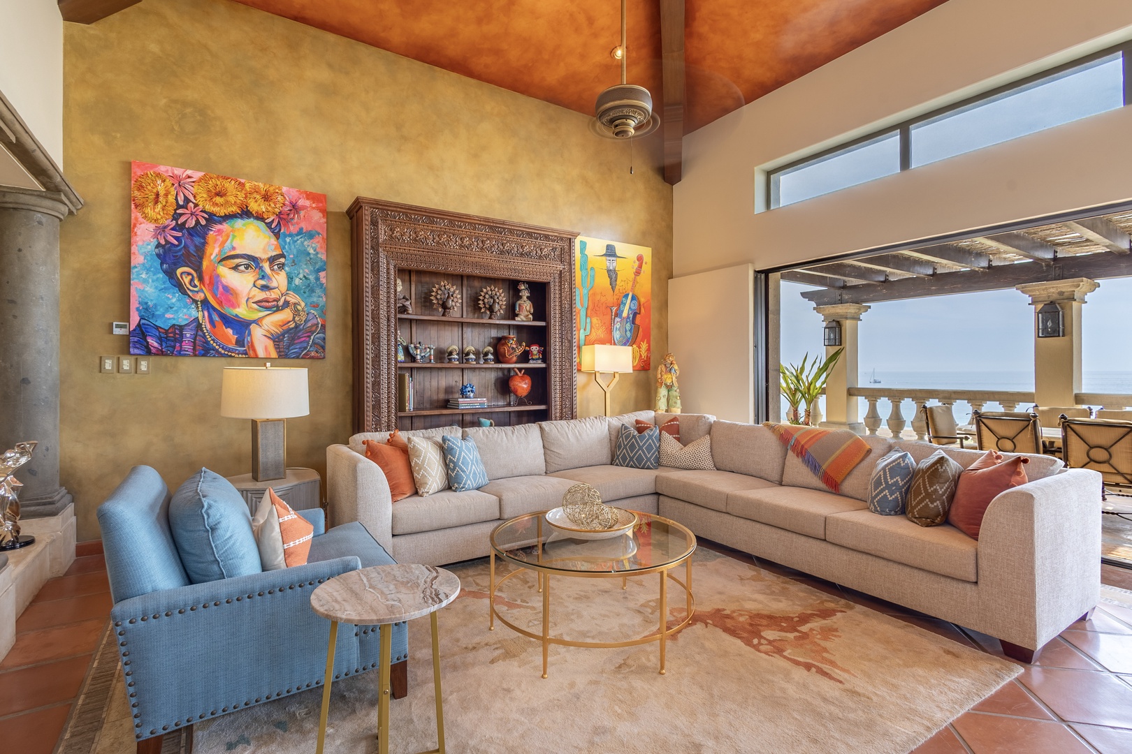 Sink into plush sofas beneath soaring wood ceilings, surrounded by vibrant art and warm textures—your perfect retreat opens to stunning ocean views just beyond.