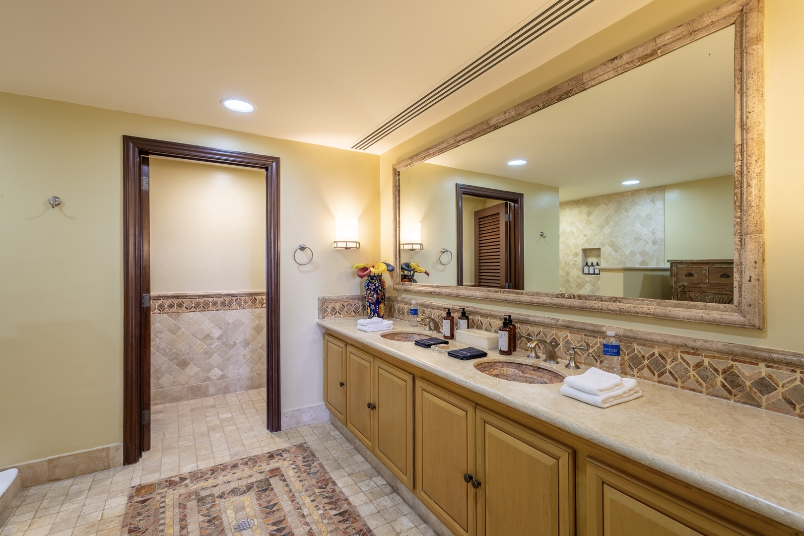 Step into your spacious bathroom, where elegant tile work and dual sinks offer comfort and style for your morning routine, while warm lighting and luxurious touches create a serene, spa-like atmosphere.