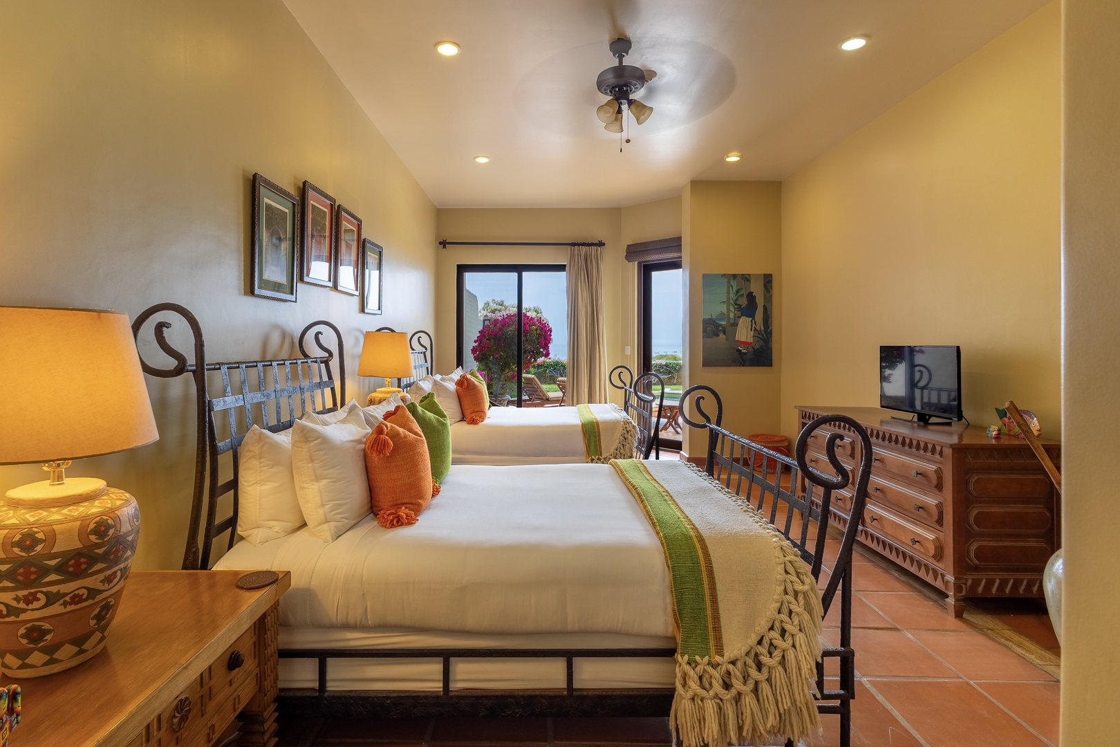 Settle into cozy comfort with two inviting beds, warm lighting, and a ceiling fan to keep you cool. Wake up to glimpses of the outdoors through windows framing colorful blooms and natural light.